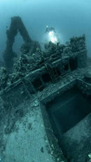 Gallipoli Wreck Diving underwater shipwreck with encrusted metal, a diver, and blue-green water 
